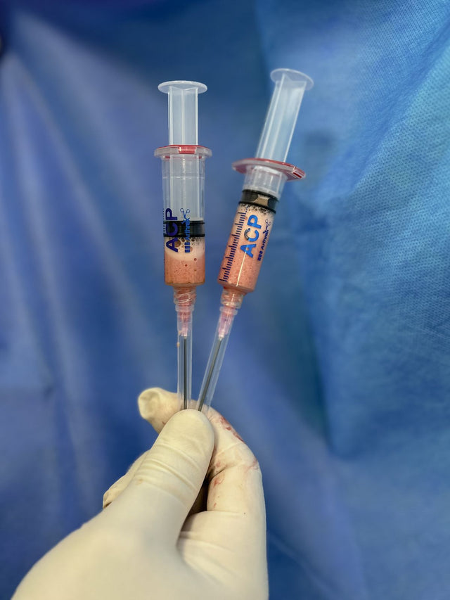 Gloved hand holding syringe