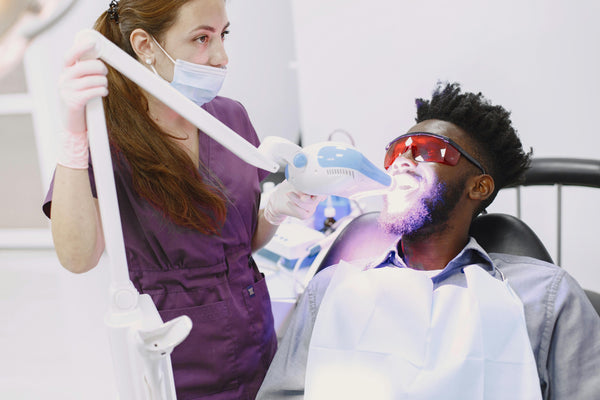 Dentist performing teeth whitening