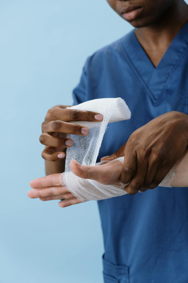 Healthcare professional wrapping hand wound