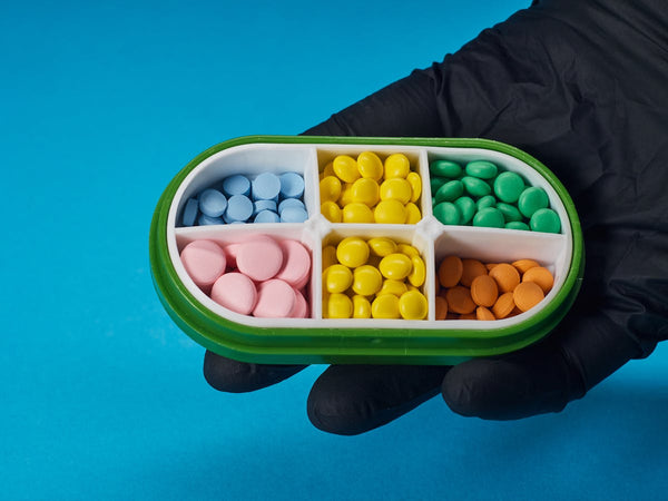 Gloved hand holding pill box