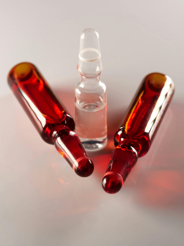 Three medical ampoules on white