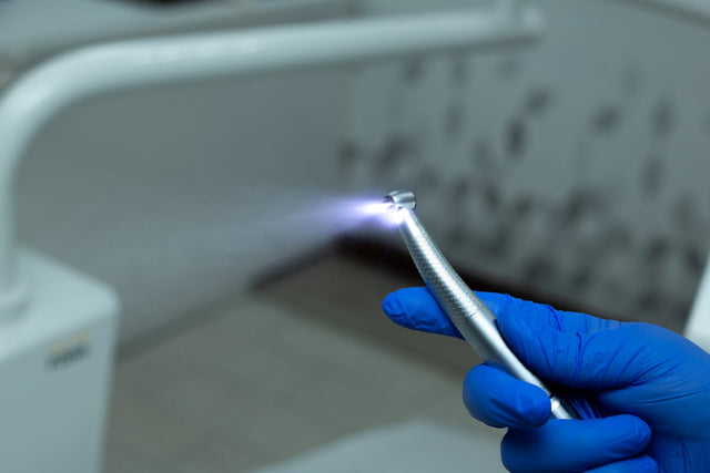 Dental handpiece in gloved hands